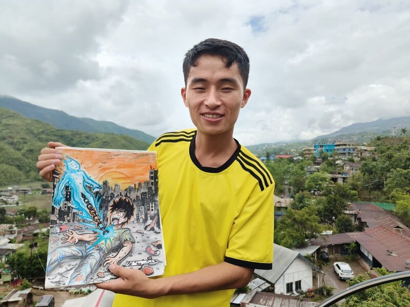 Portrait of Sotam Francis Soro, deaf student artist at Star Sign School, holding one of his manga-style illustrations